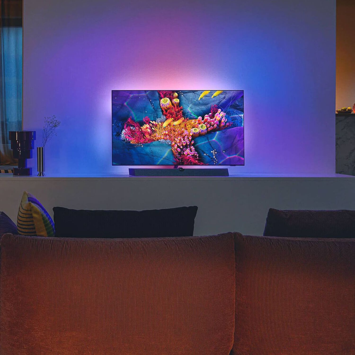 Philips OLED+937 in living room with purple, blue and orange lights behind TV