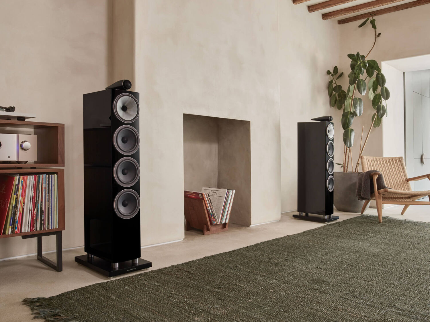 Two black 700 Series loudspeakers facing diagonal right surrounding books