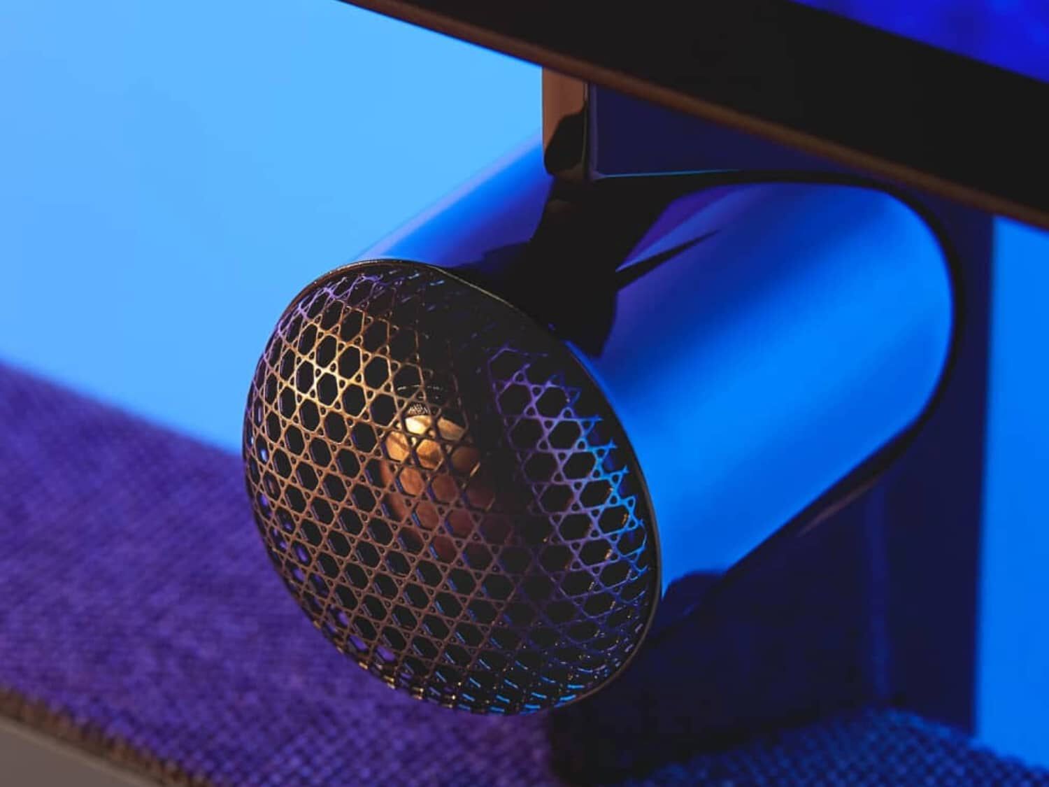 Black small circular speaker with blue background