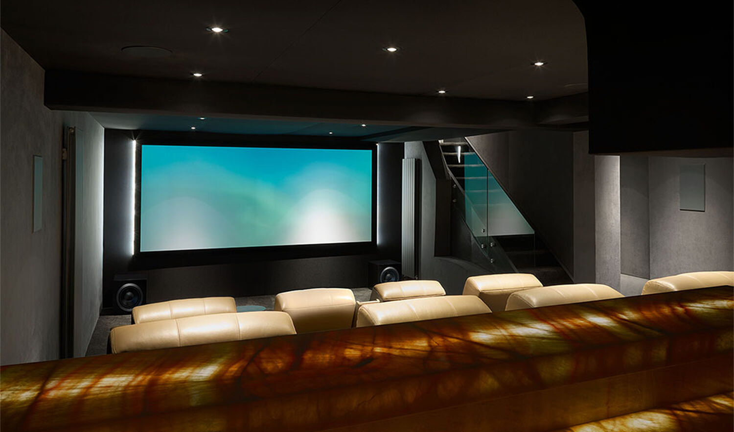 Home theater with dark walls and light leather furniture