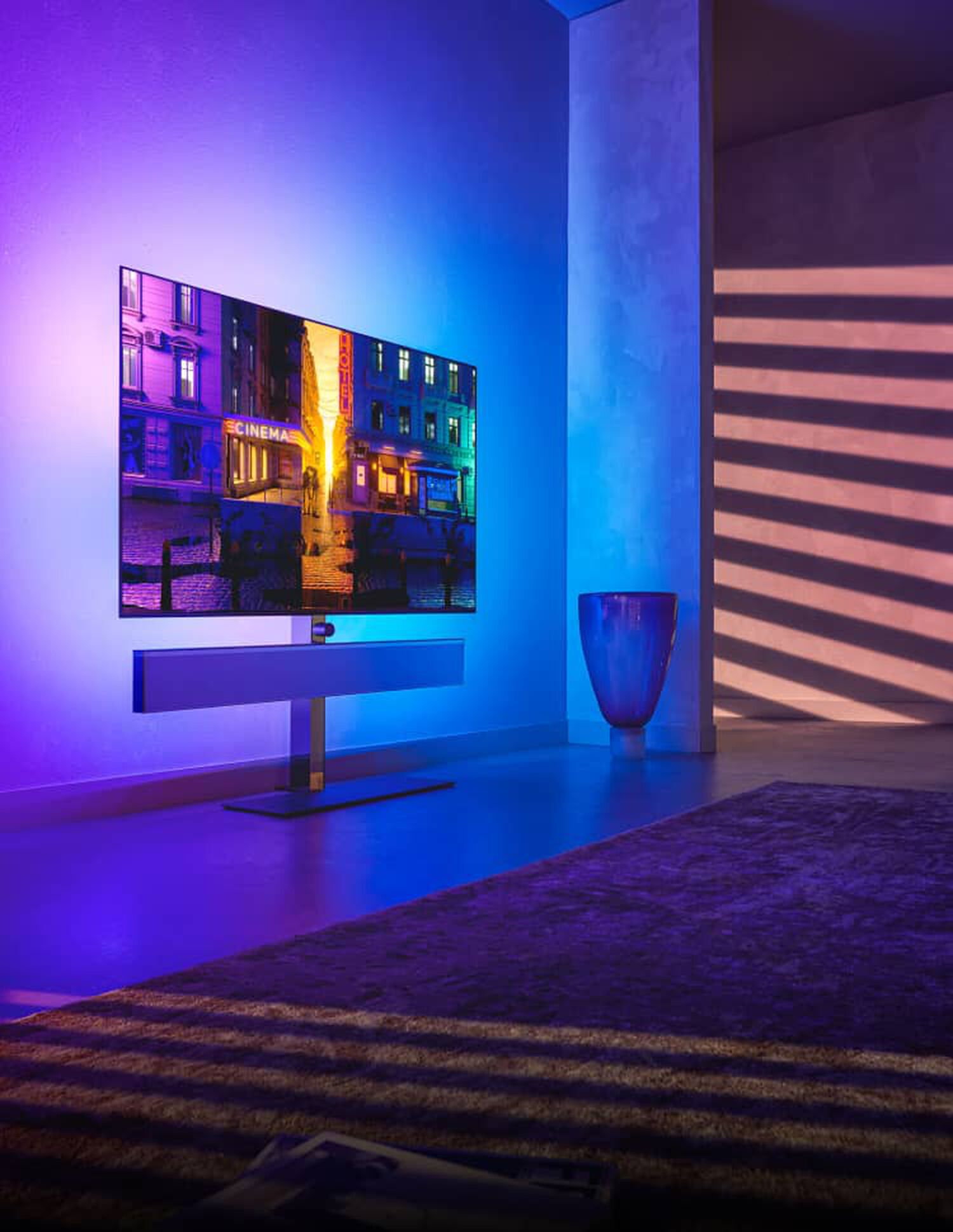TV on stand with floating sound bar with blue and purple illimitation behind 