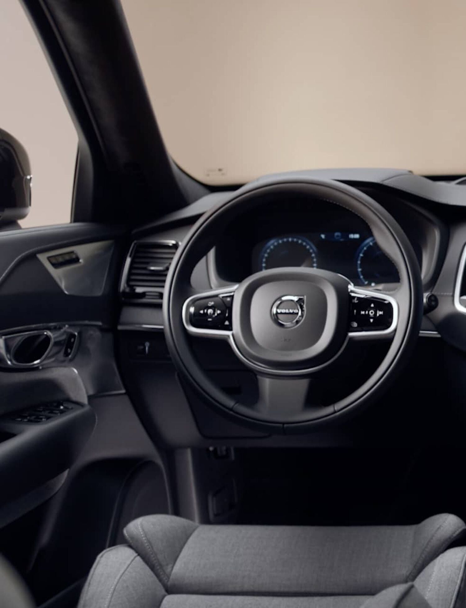 Driver side of car with gray leather seats and black steering wheel