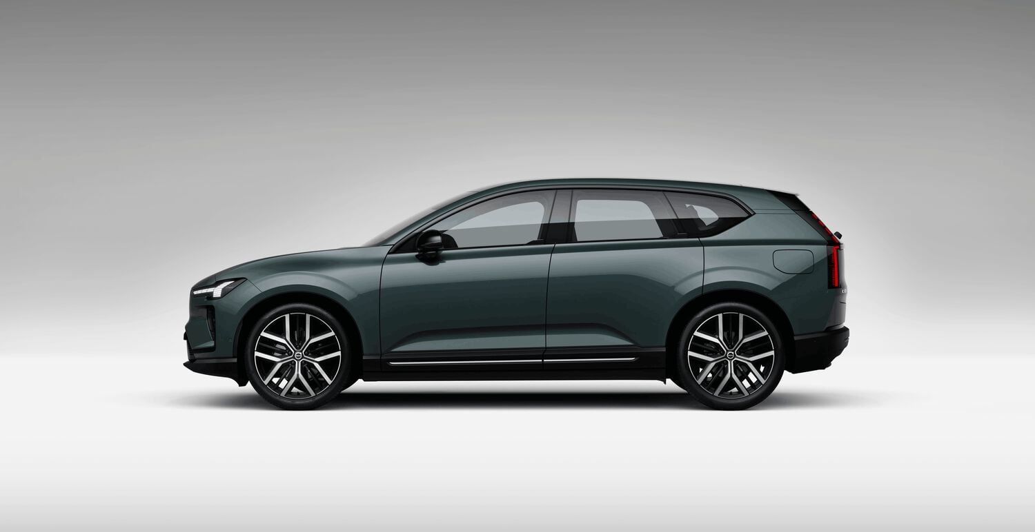 Green Volvo EX60 car left facing with grey shadow background