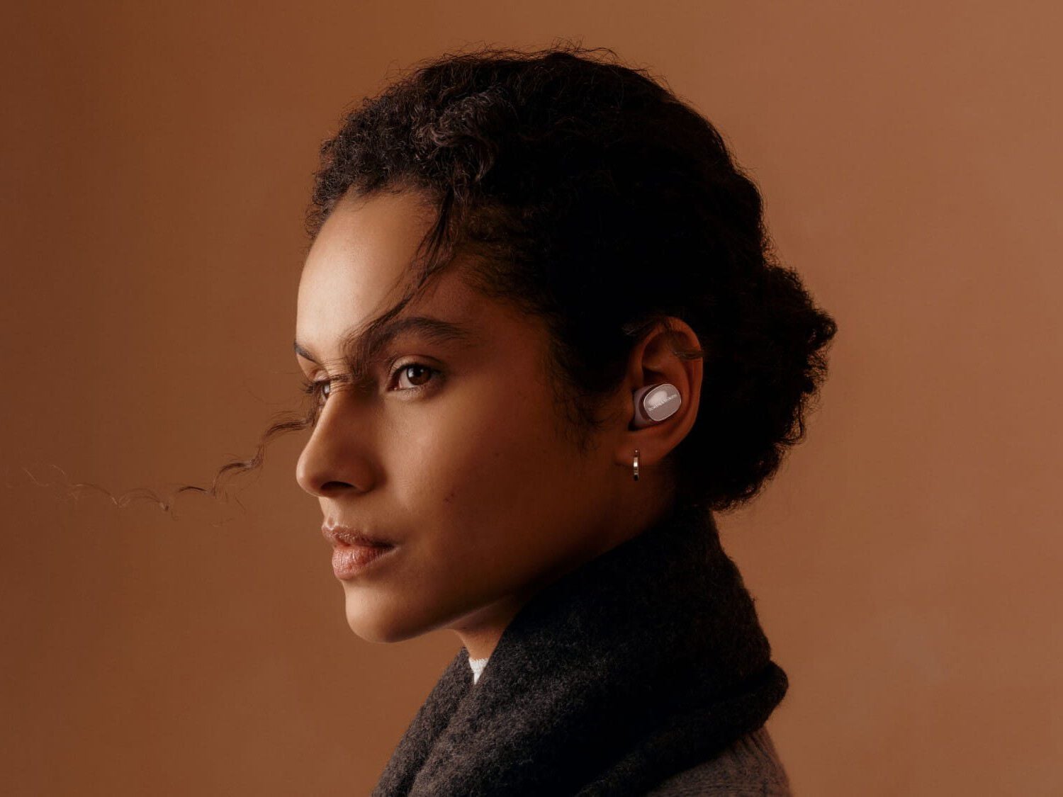 Woman facing left wearing Pi8 with brown background