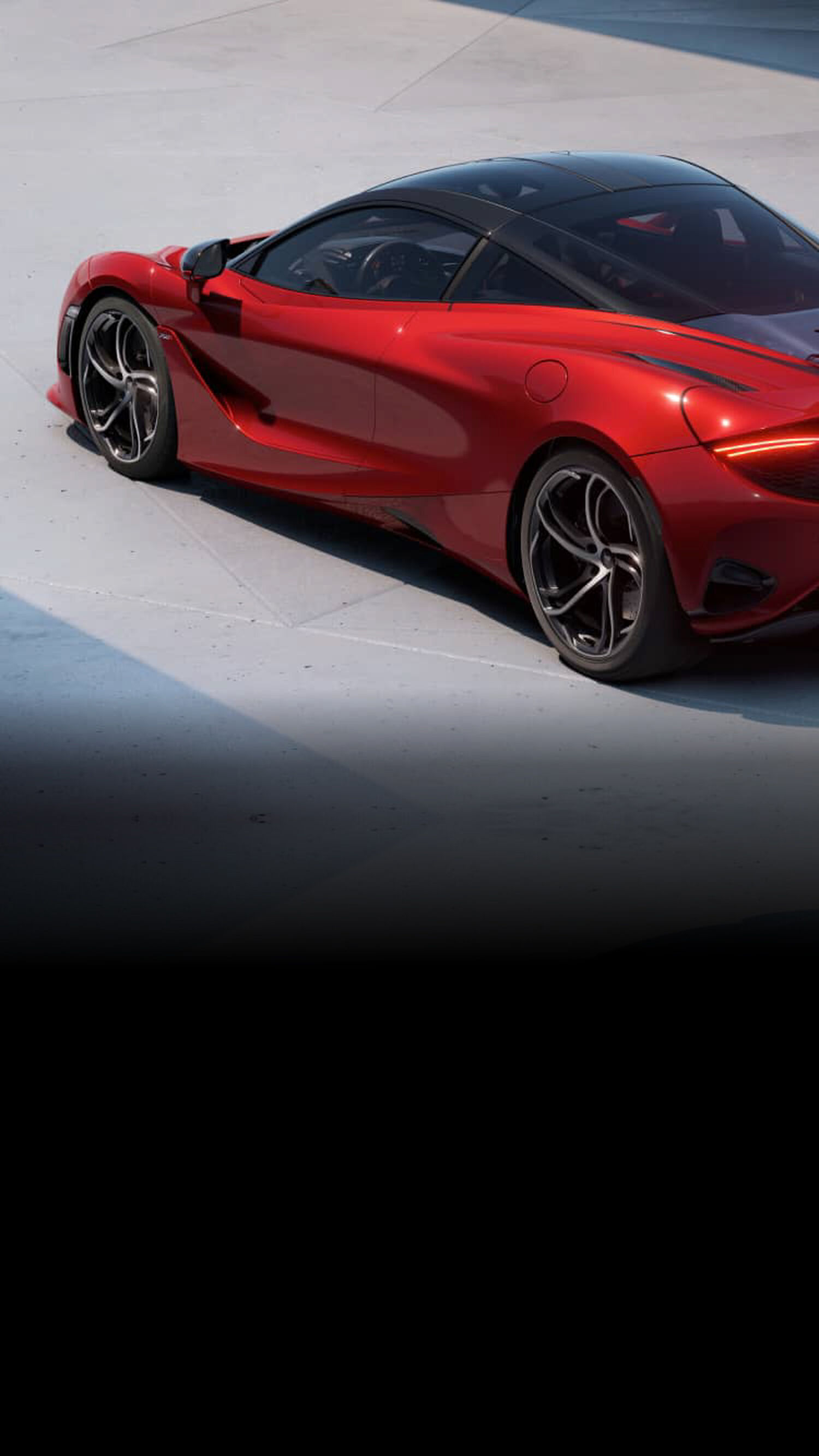 Red McLaren car facing top left on concrete