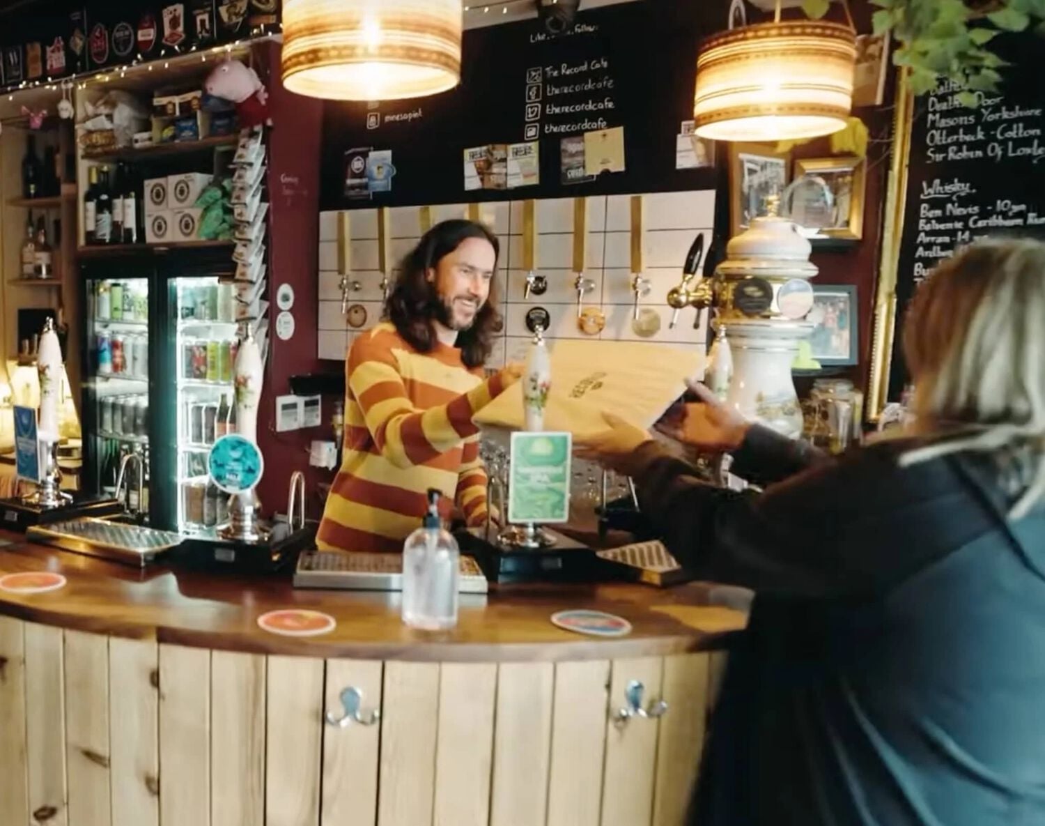 Man selling record in cafe with taps on wall