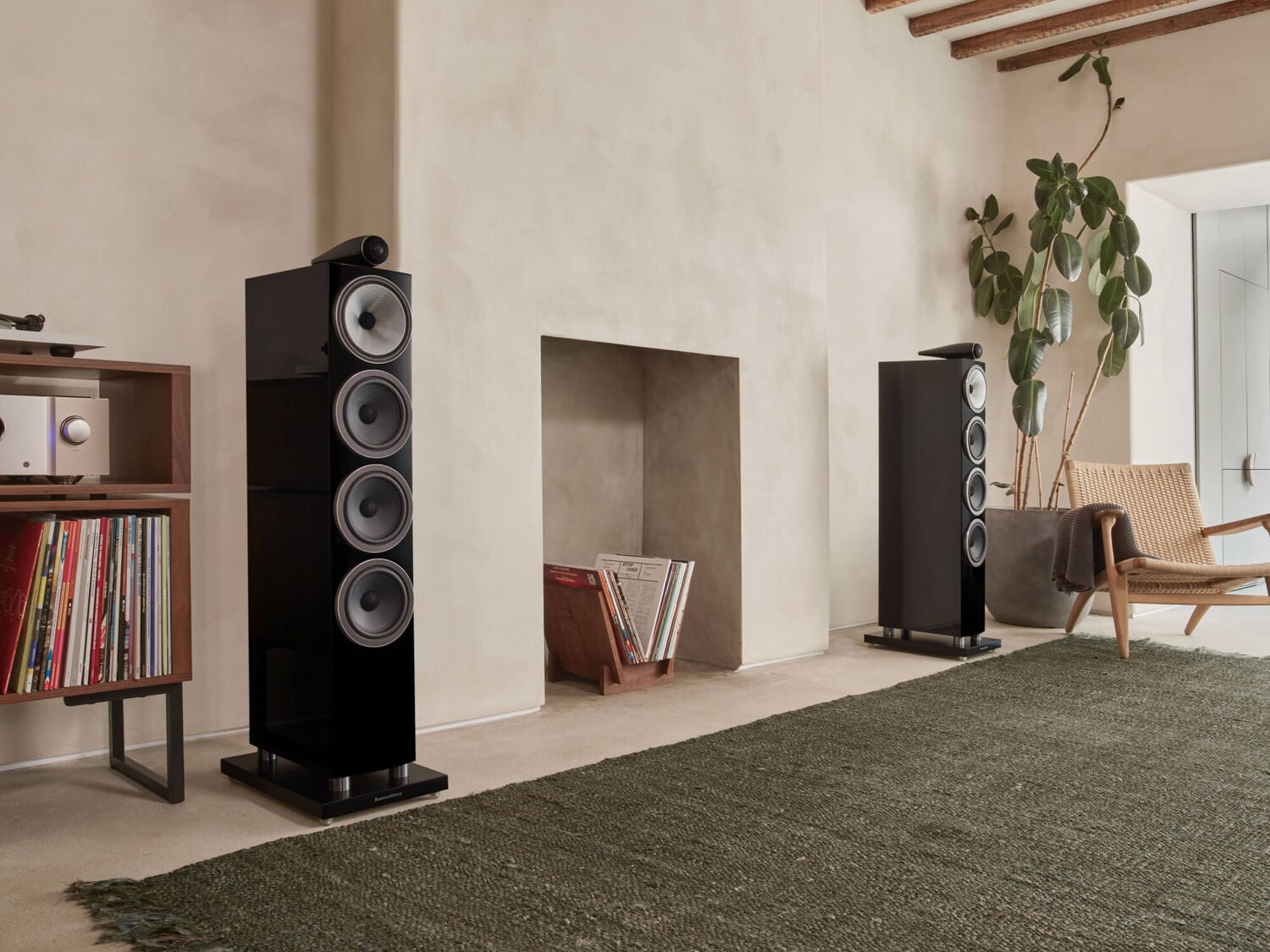 Two black 700 Series loudspeakers facing diagonal right surrounding books