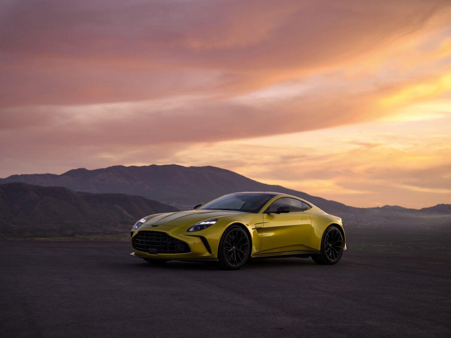 Aston Martin Vantage yellow with sunset behind