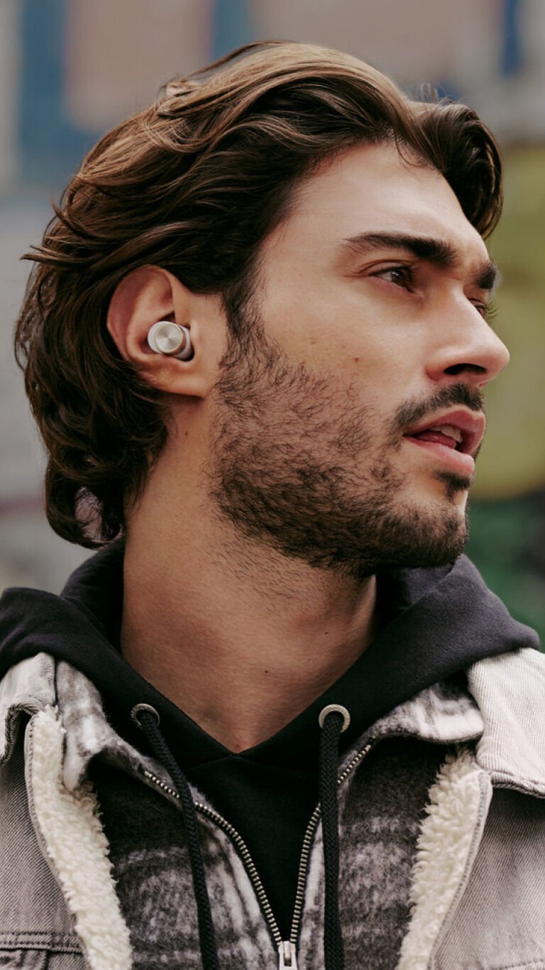 Man wearing wireless earbuds looking right.