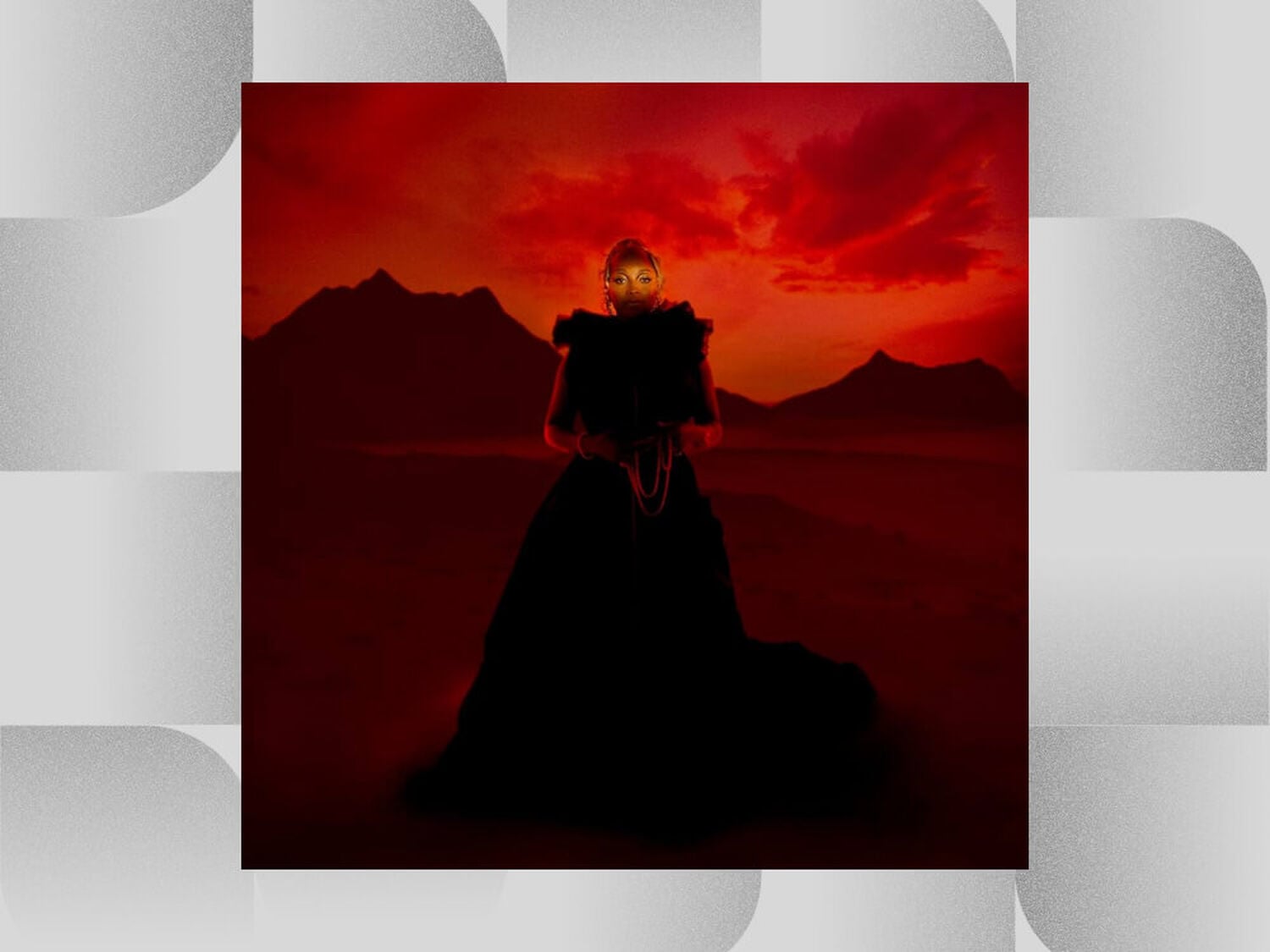 Woman in black gown standing with mountains behind with red sky