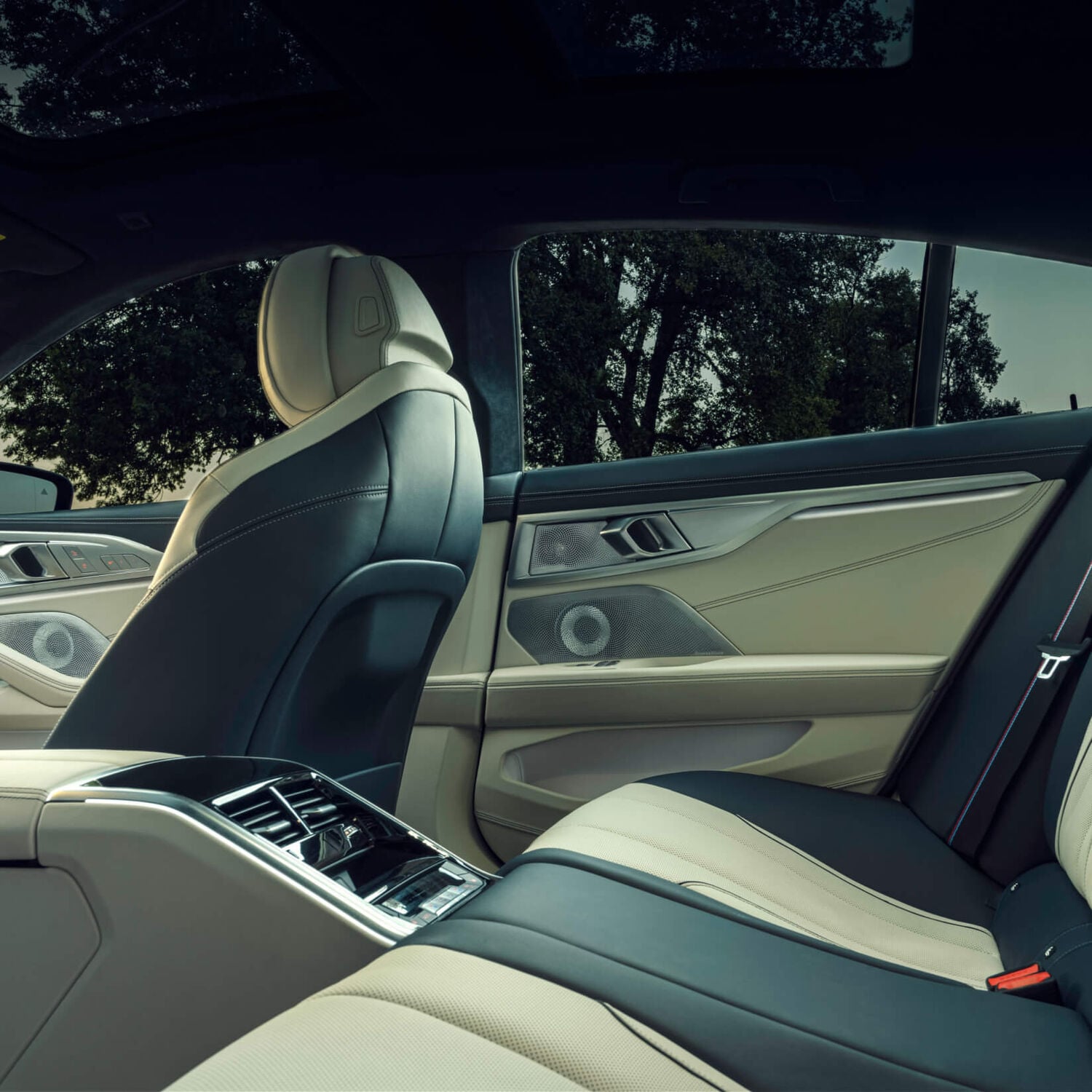 Right side of car with black and tan leather interior with silver Bower & Wilkins car speakers
