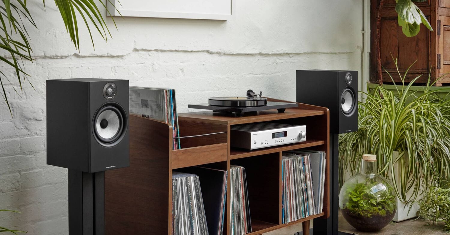 2 Black Bowers & Wilkins 600 series speakers next to record storage cabinet