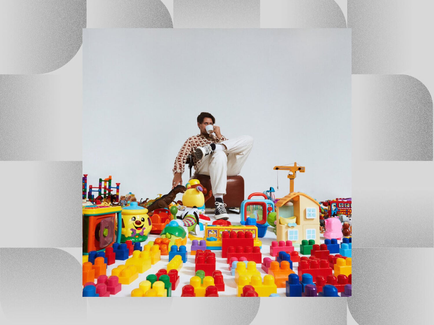 Man sitting on chair in room full of colorful toys