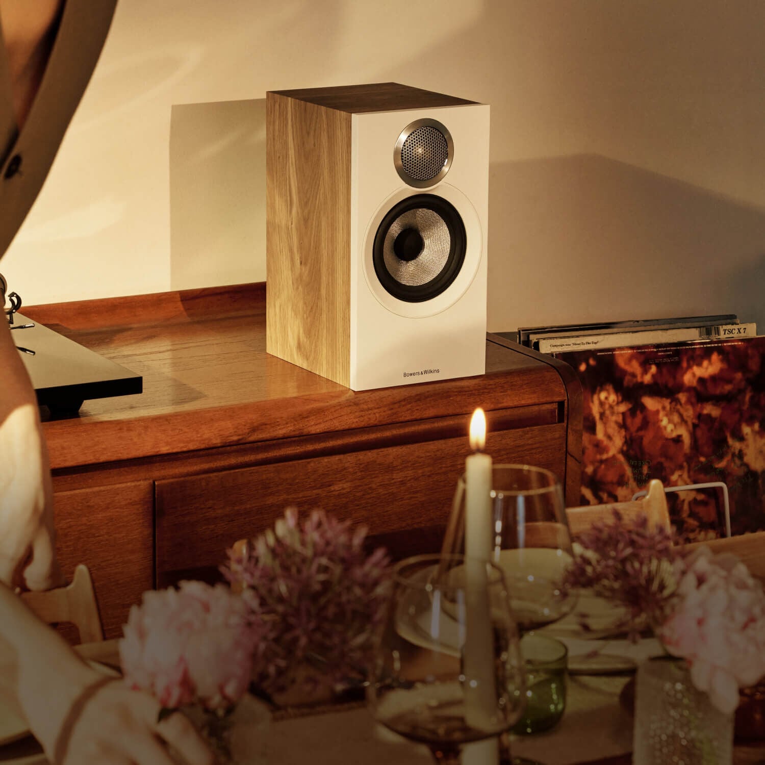 Woman walking by 600 Series loudspeakers and a turntable