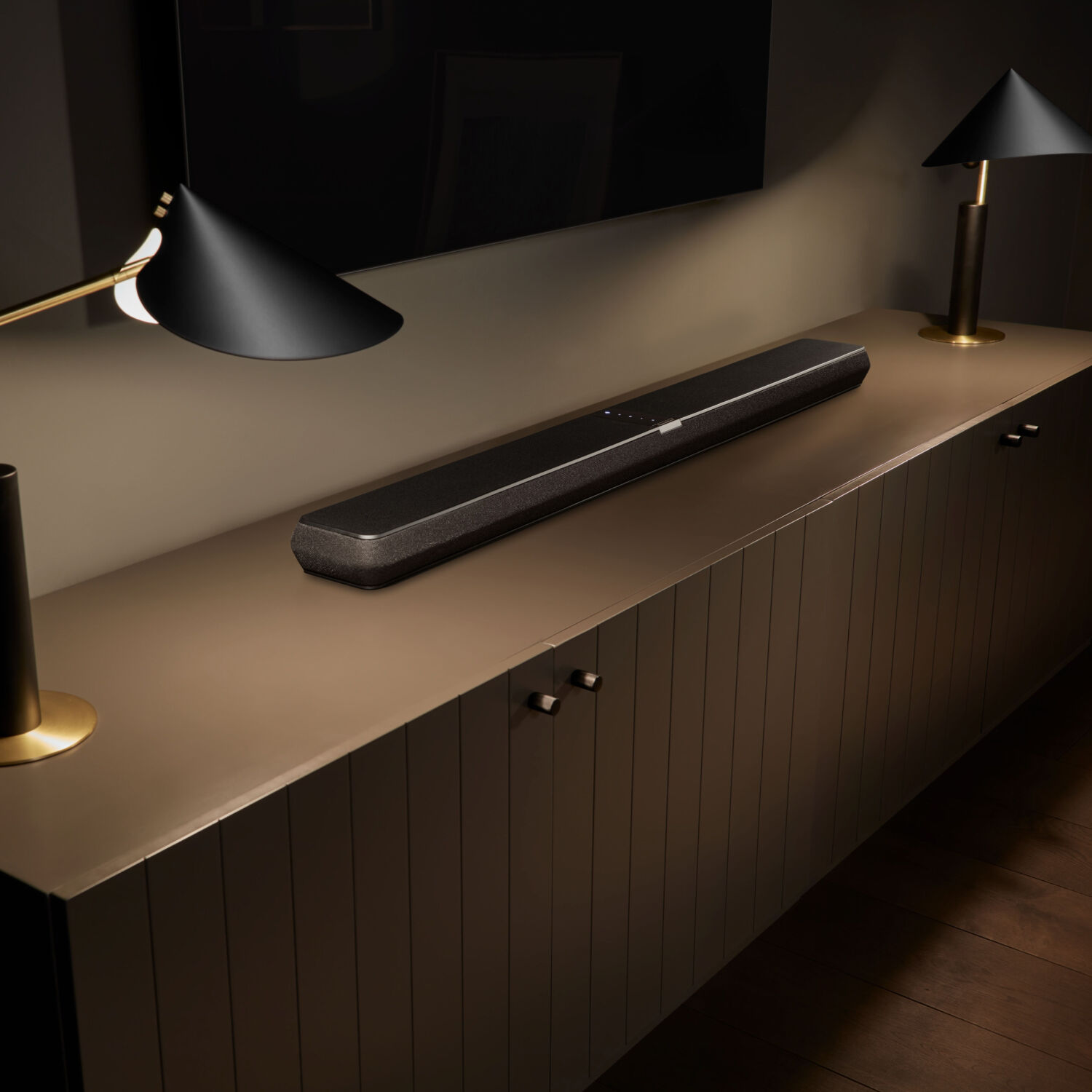 Black soundbar on top of brown media console