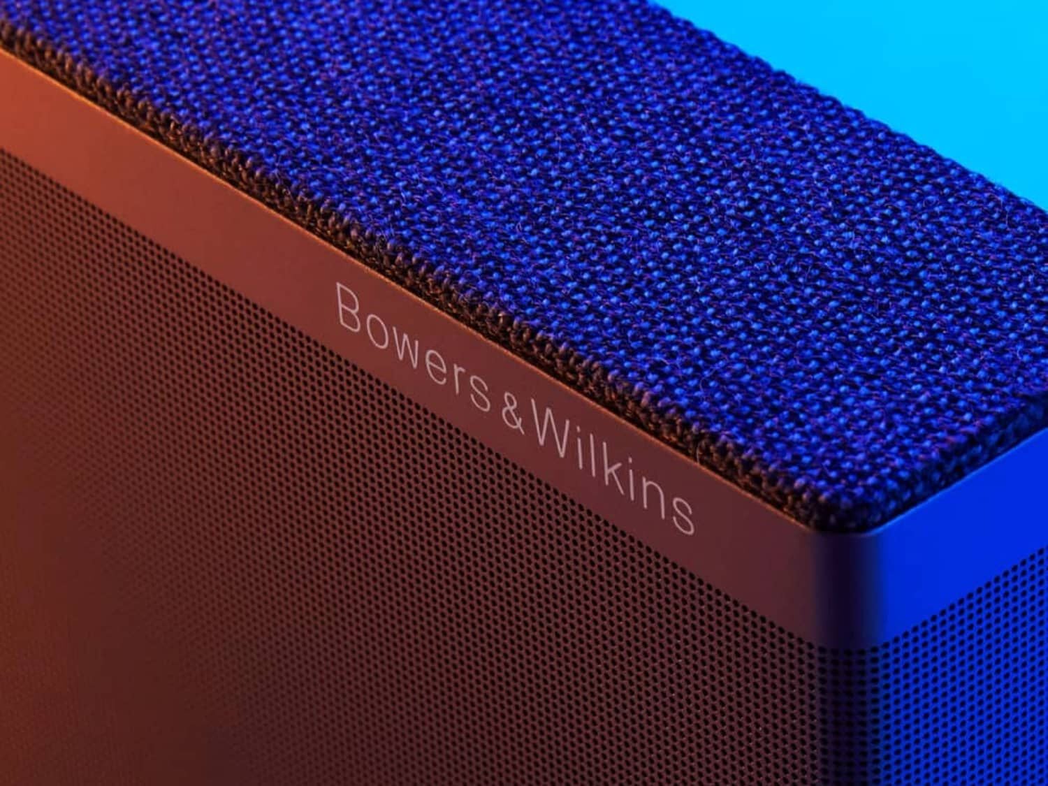 Black rectangular Bowers & Wilkins speaker with blue background facing right