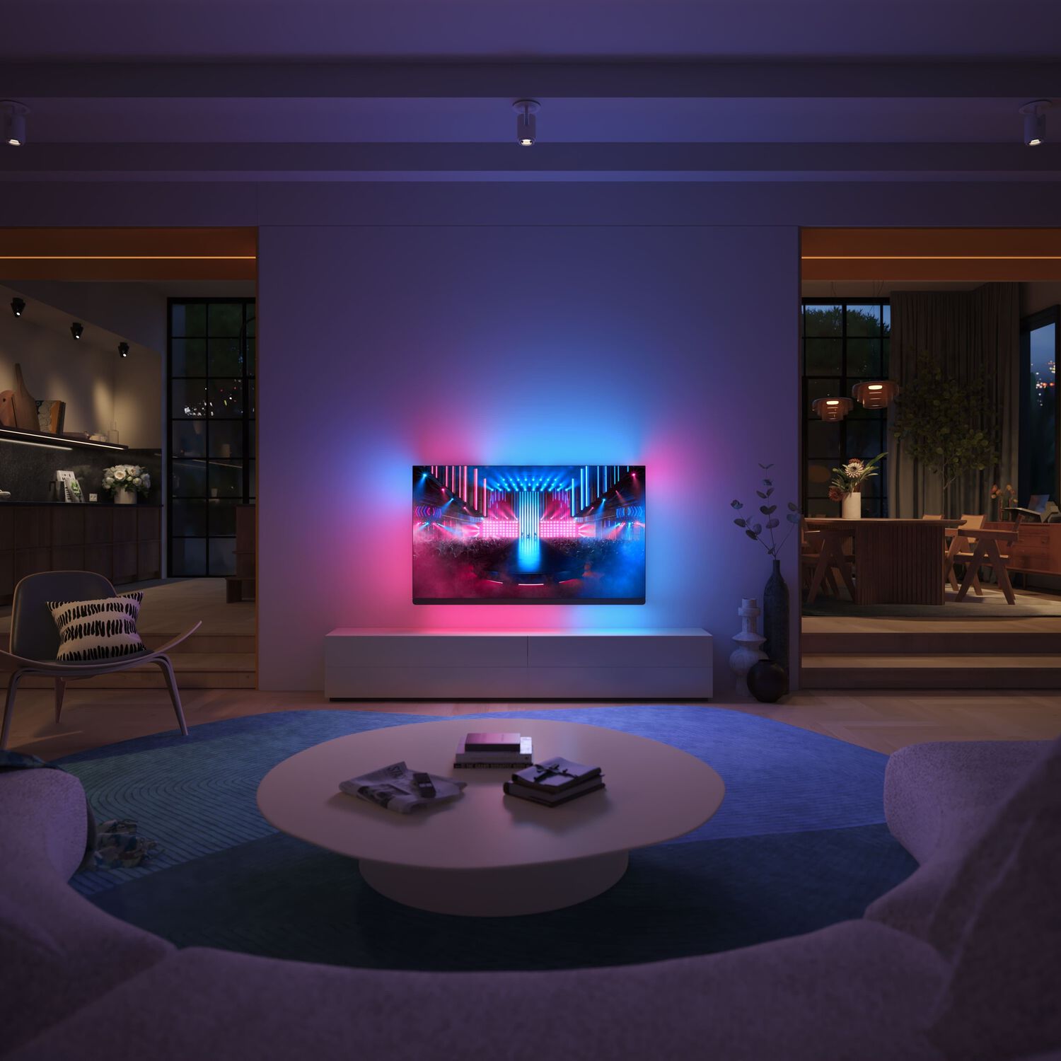Living room with wall mounted TV with red and blue lights behind, white curved sofa, blue circle rug and white coffee table