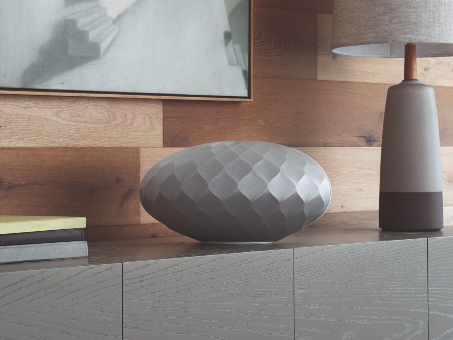 Silver speaker on gray wood media console