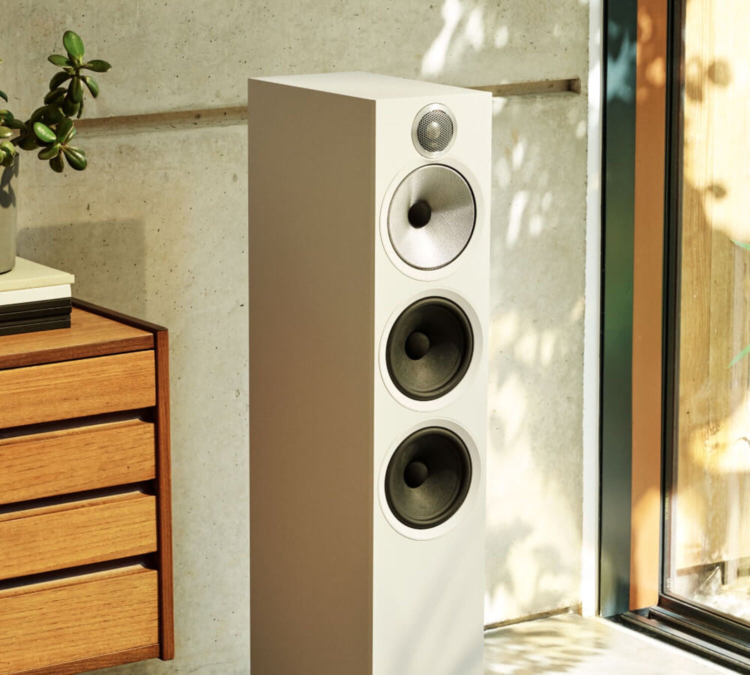 One white 600 series loudspeaker sitting in the corner