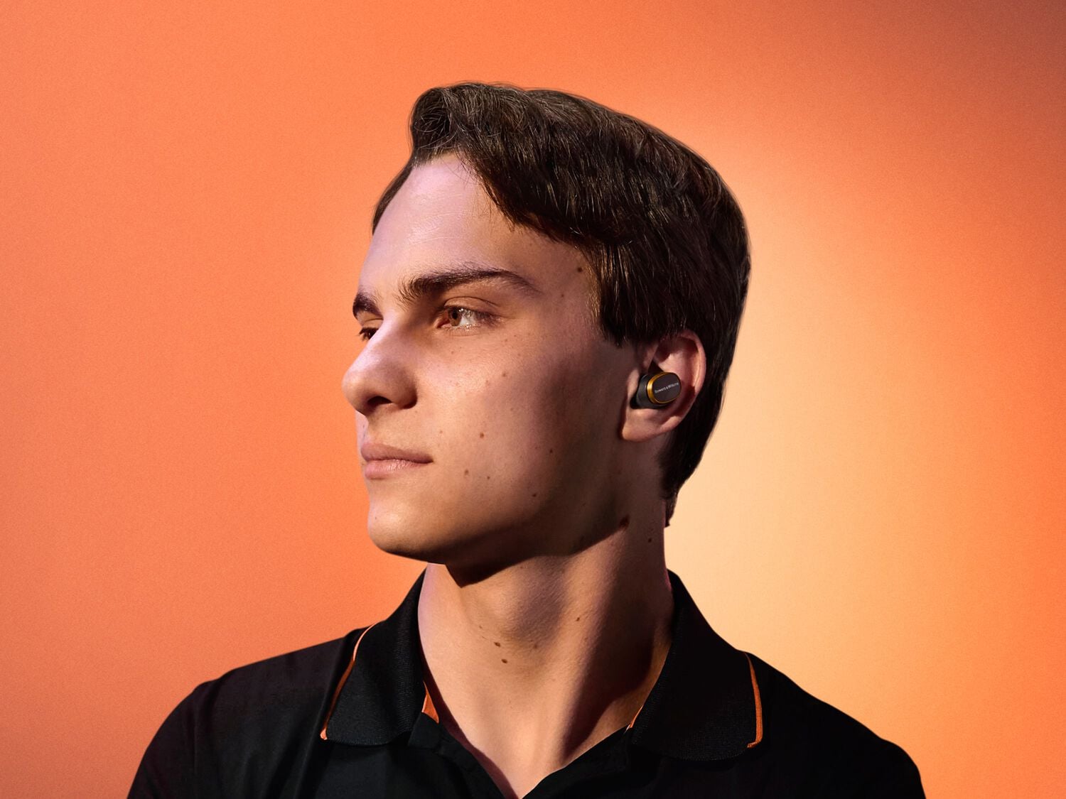Man wearing Pi8 McLaren Edition facing left with orange background