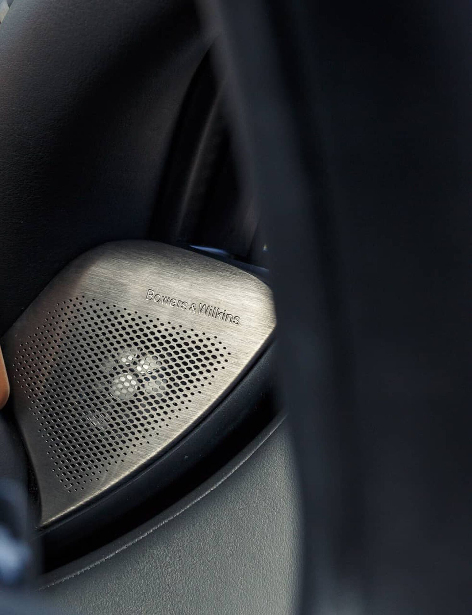 Silver Bowers & Wilkins car speaker with visible speaker cutouts