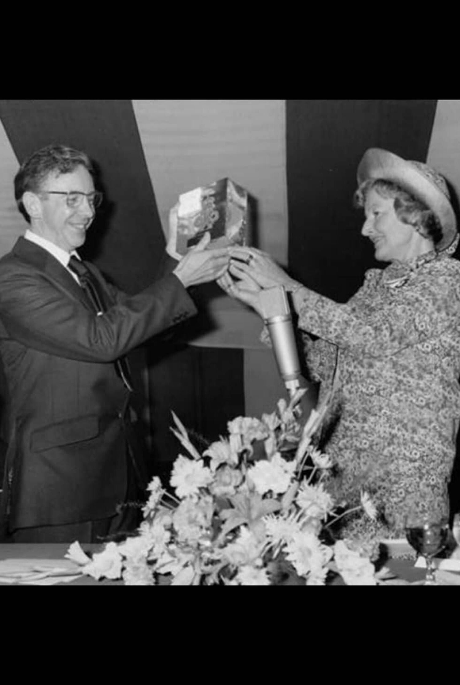 Man and woman holding award in black and white