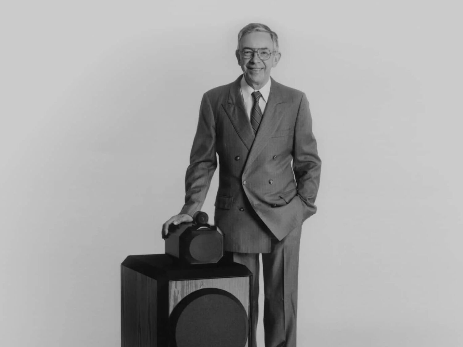 Man standing next to speaker in black & white