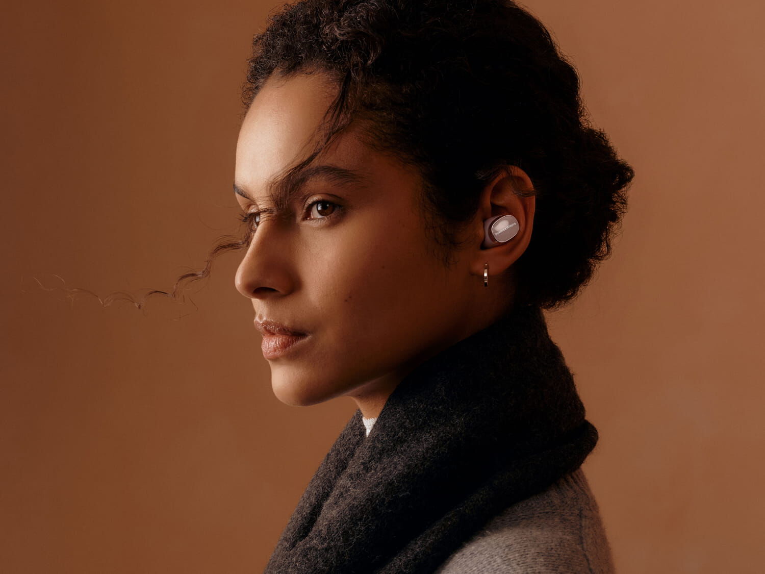 Woman facing left wearing Pi8 with brown background