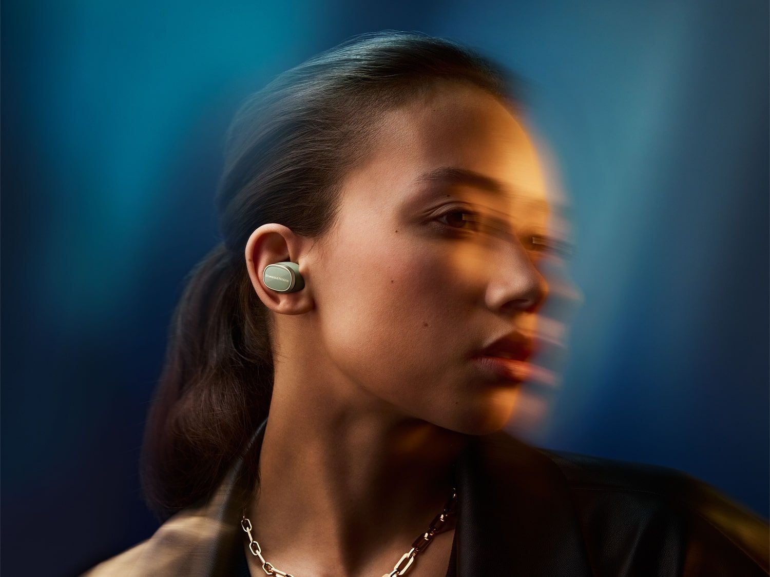 Woman wearing earbuds looking right