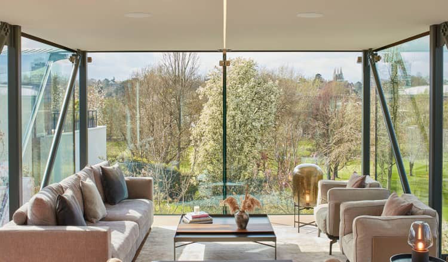 Living room with large windows showing trees