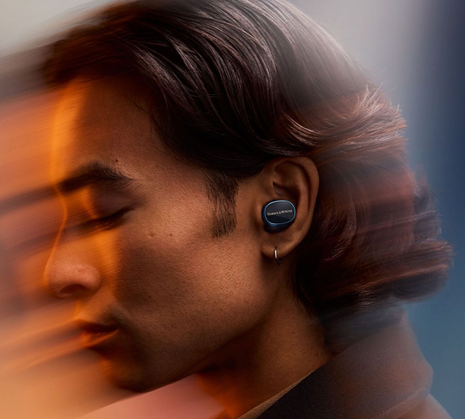 Man wearing earbuds facing left