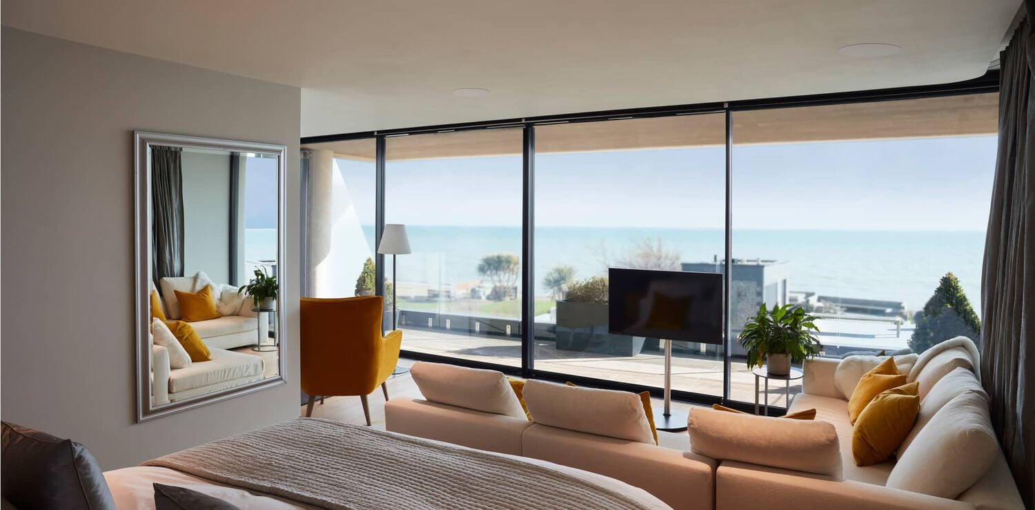 Bedroom with large windows looking at ocean