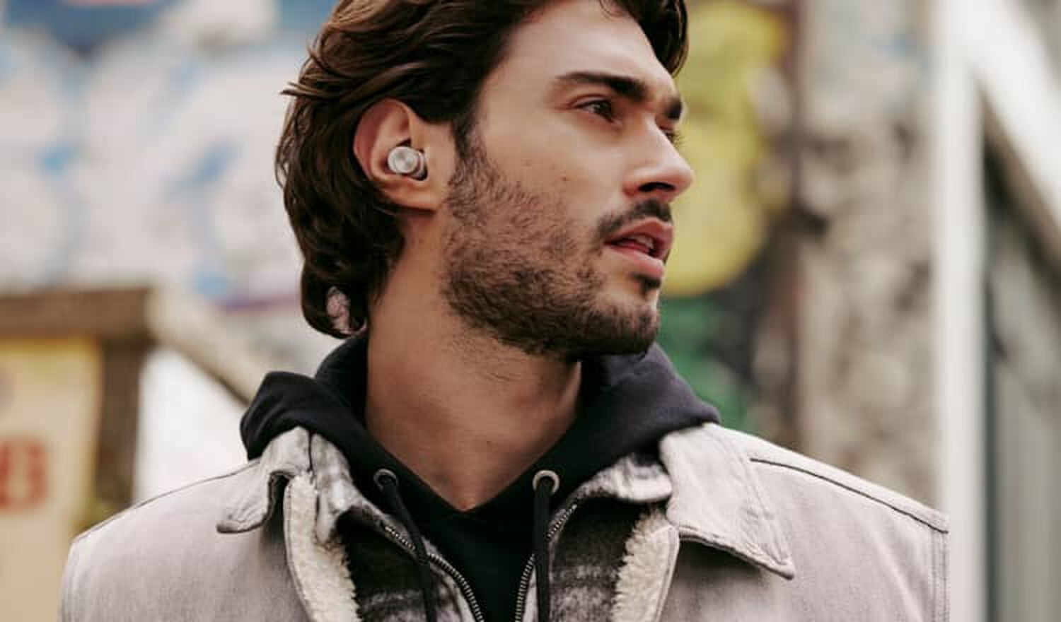 Man wearing earbuds facing right