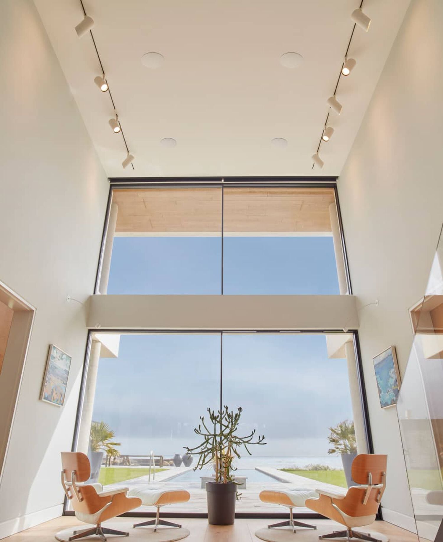 Sitting room with floor to ceiling windows overlooking pool