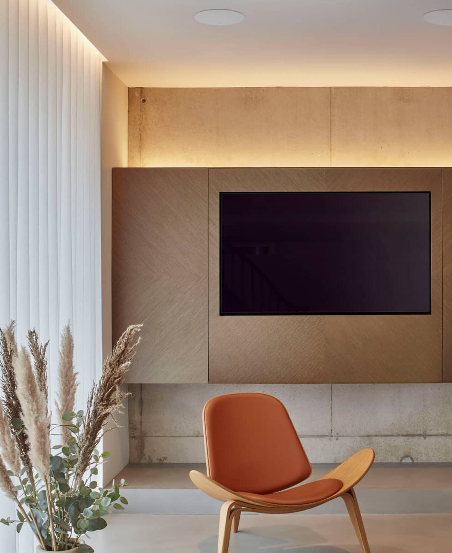 Wall mounted TV with orange chair