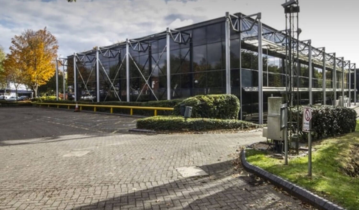 Glass building surrounded by trees and shrubs