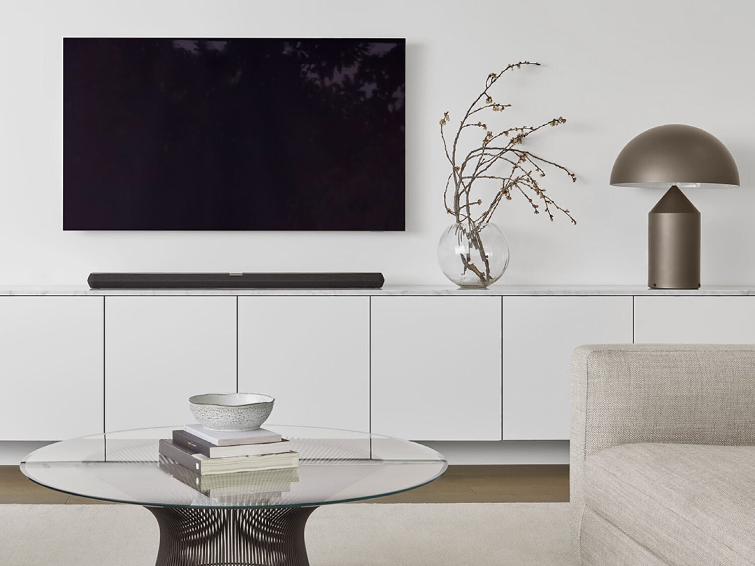 White living room with black soundbar on white media console