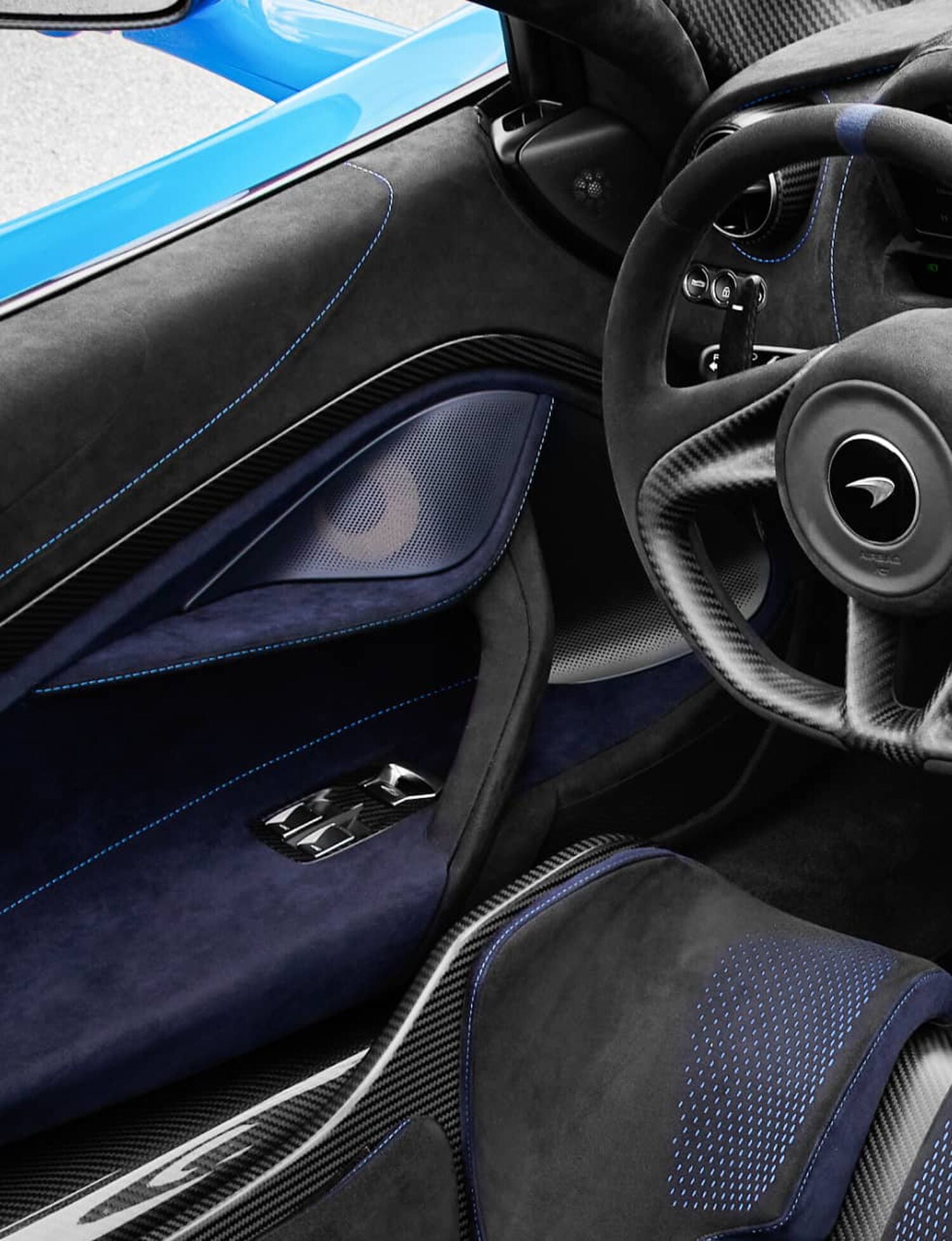 Interior of McLaren Car with blue and black suede, with blue car door speaker