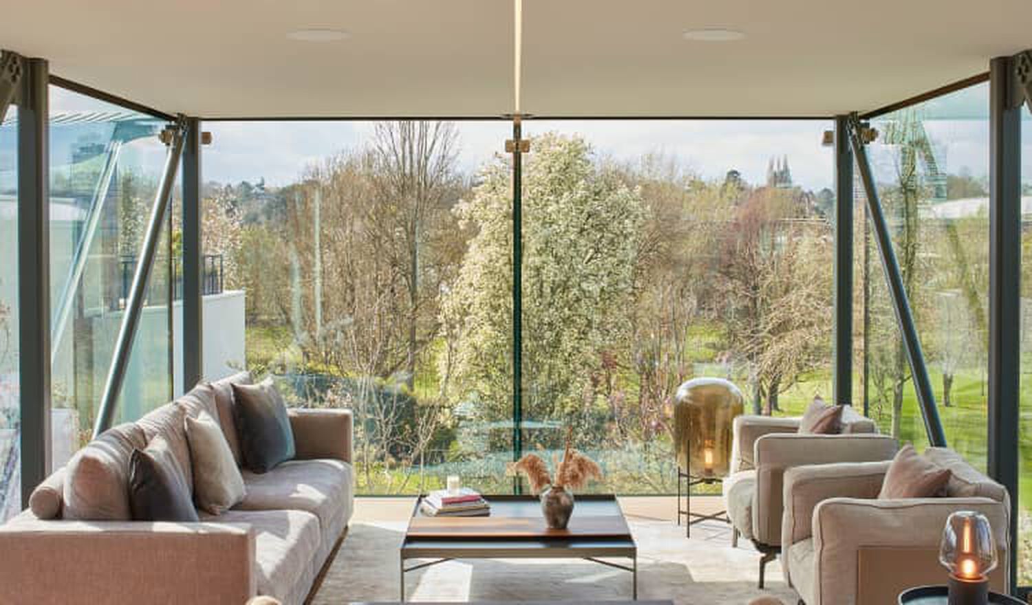 Living room with large windows showing trees