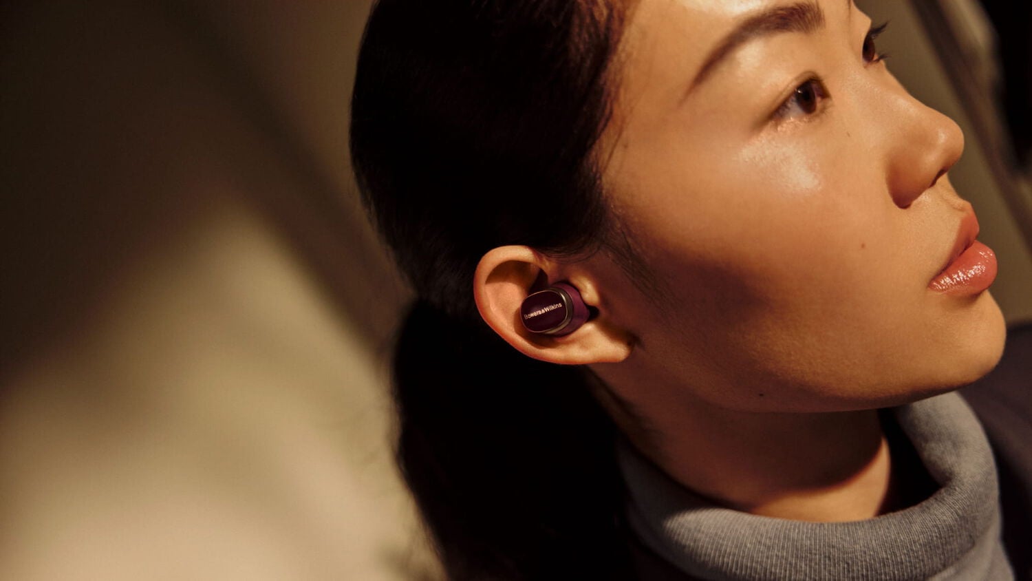 Woman wearing earbuds facing right