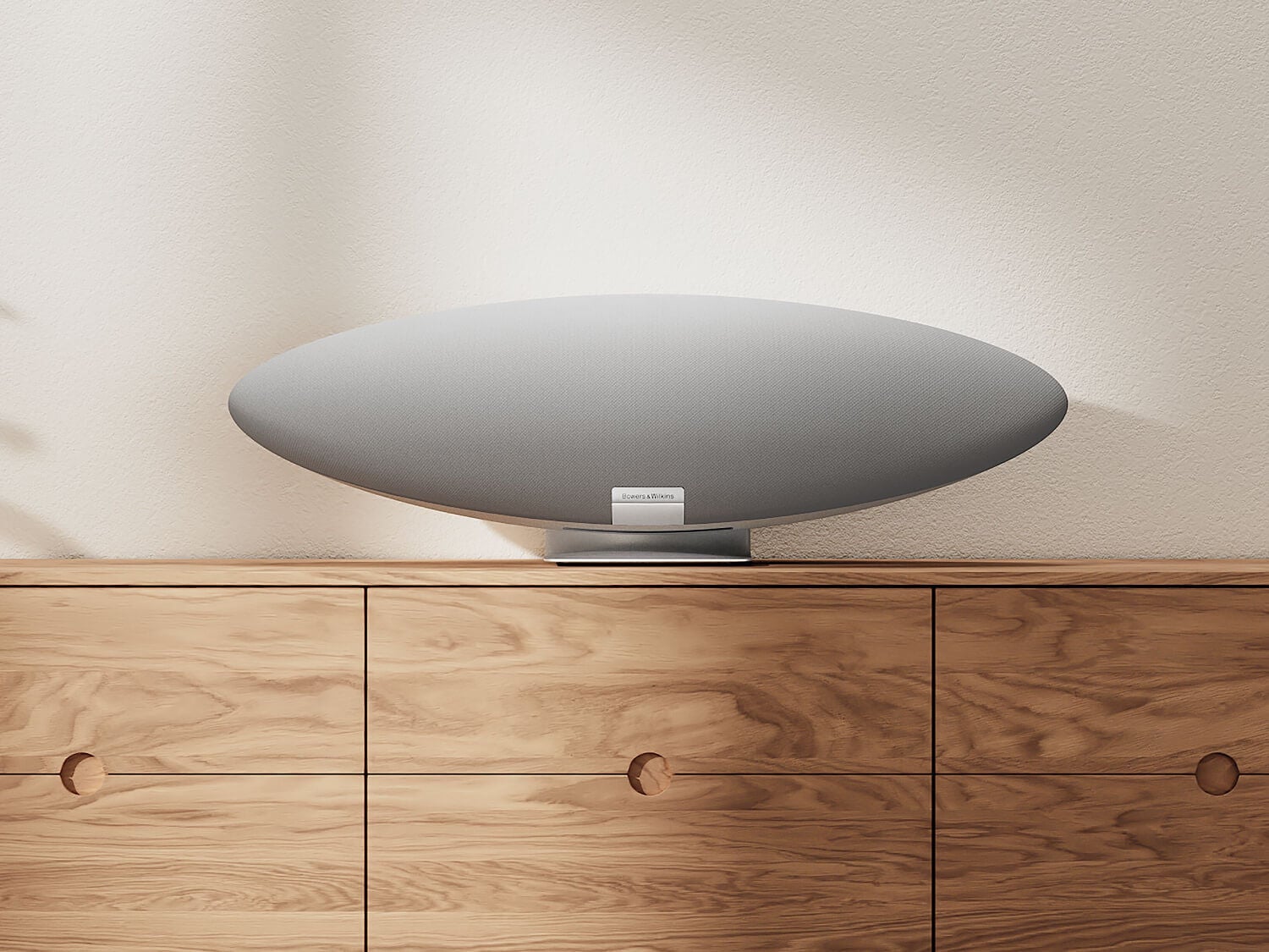 White wireless speaker on wooden console